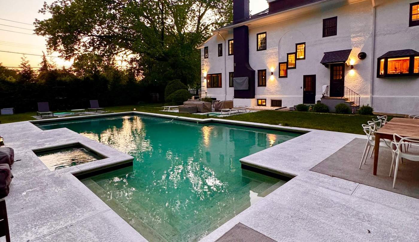 The back of the house at dusk — pool and lawn